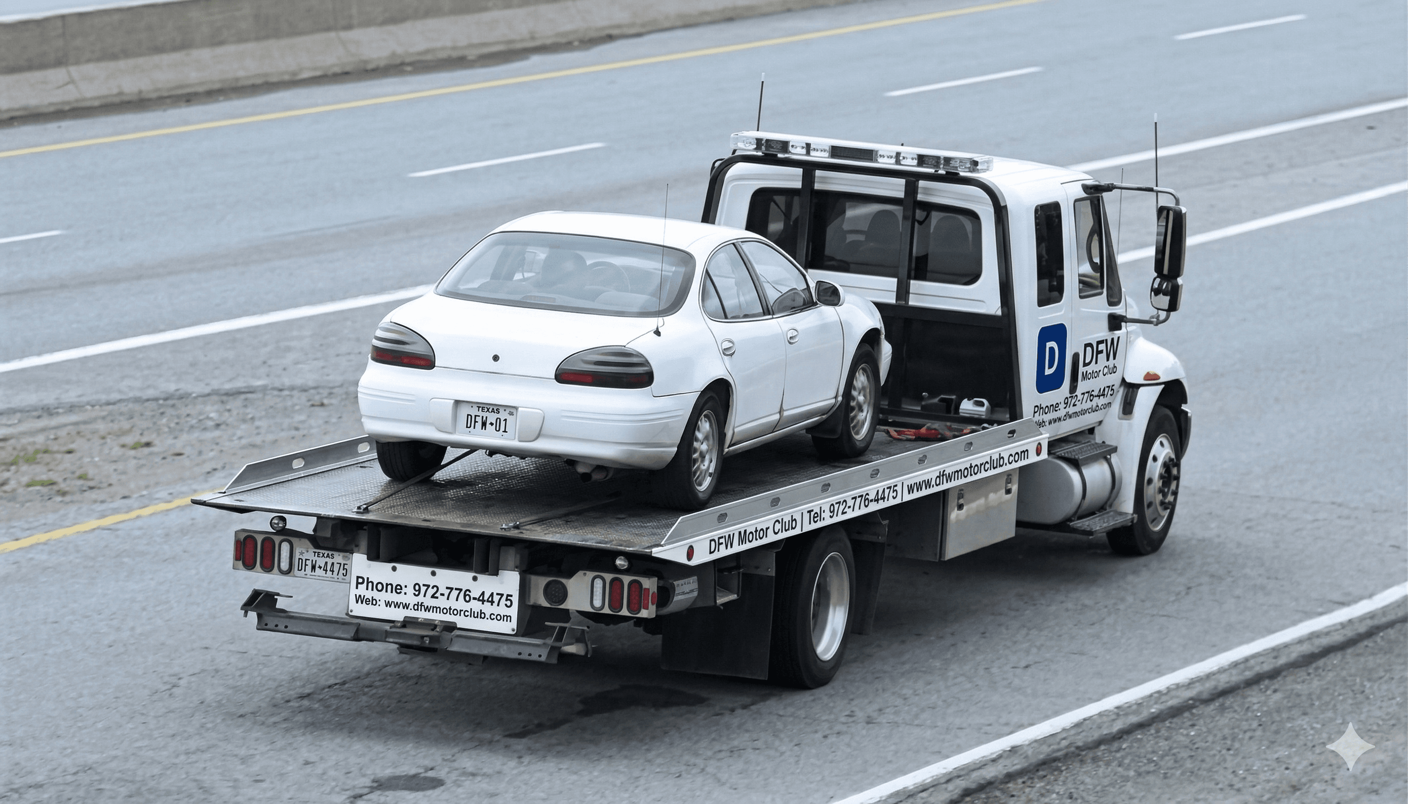 DFW Motor Club flatbed tow truck hauling a vehicle on the highway